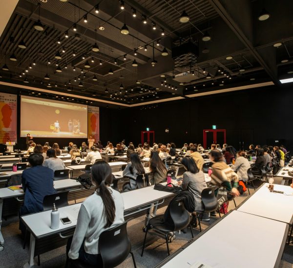 A diverse group attending a conference in a modern hall in Gwangju, South Korea.